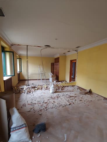 Imagen de una sala durante el proceso de reforma interior por MAM Experience Building, mostrando un espacio con escombros, materiales de construcción y herramientas utilizadas para la renovación.