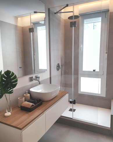 Imagen de un baño reformado por MAM Experience Building, mostrando una ducha de vidrio, un lavabo sobre encimera y un diseño moderno y elegante.